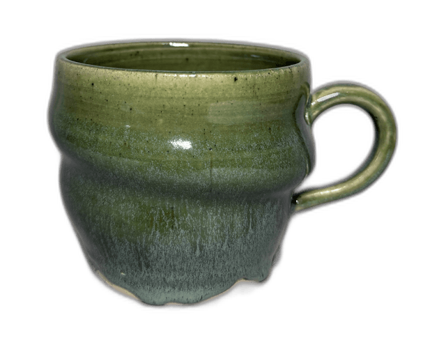A green-glazed mug photographed in the studio