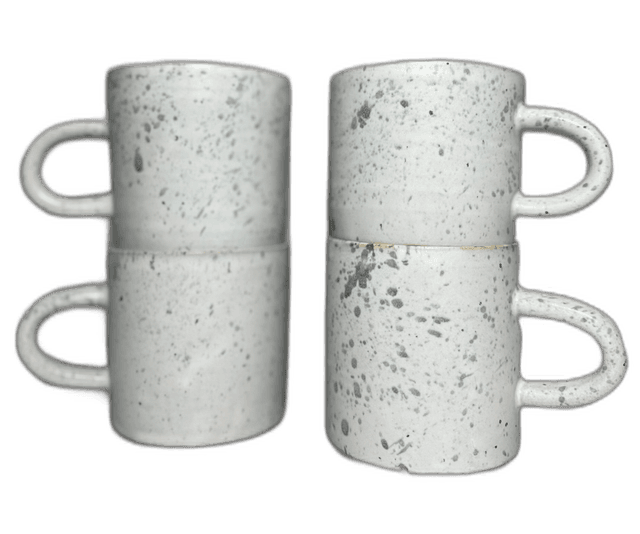 A stacked pair of speckled mugs photographed in the studio
