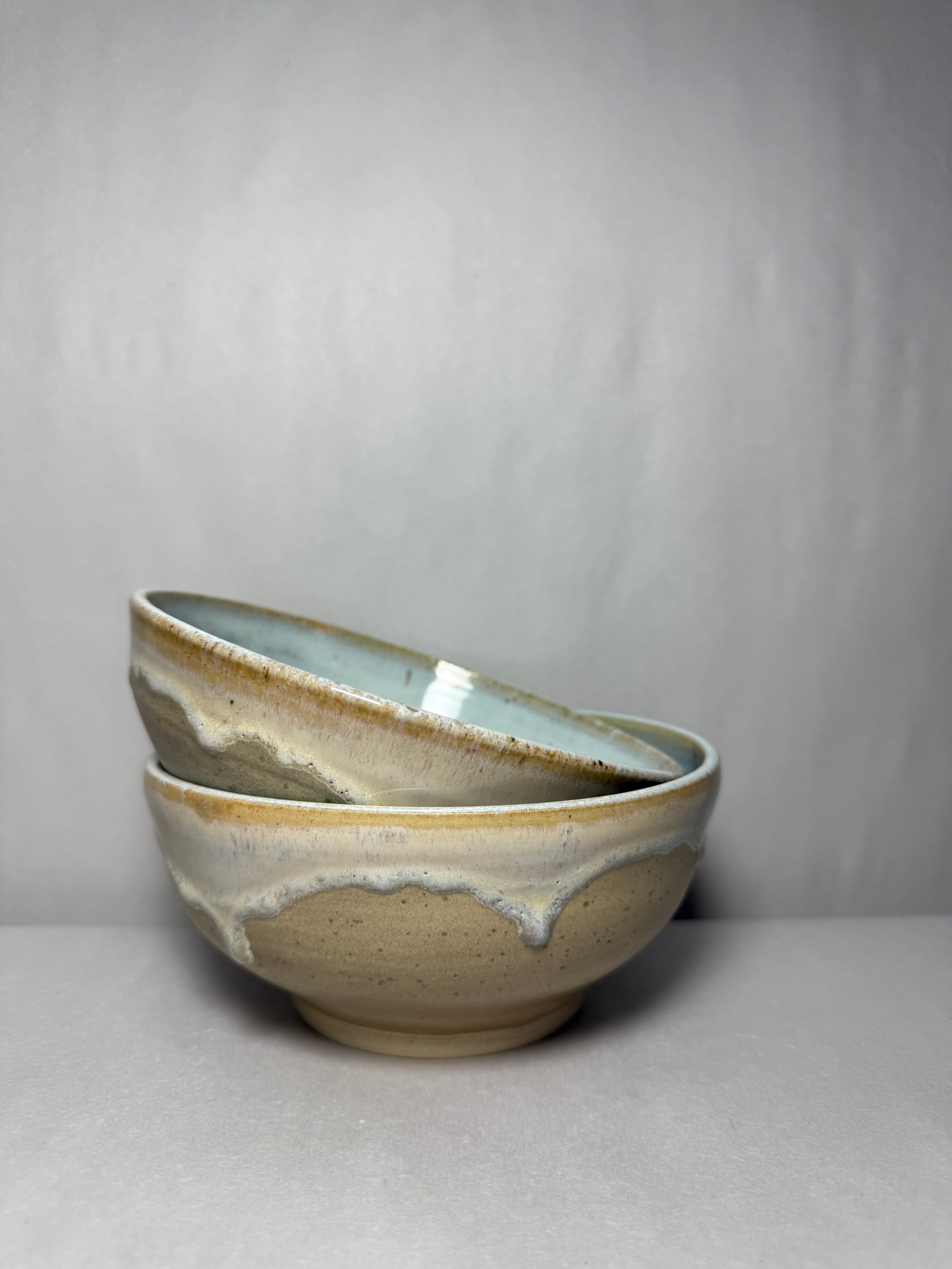 A nested pair of bowls with ochre drip rims