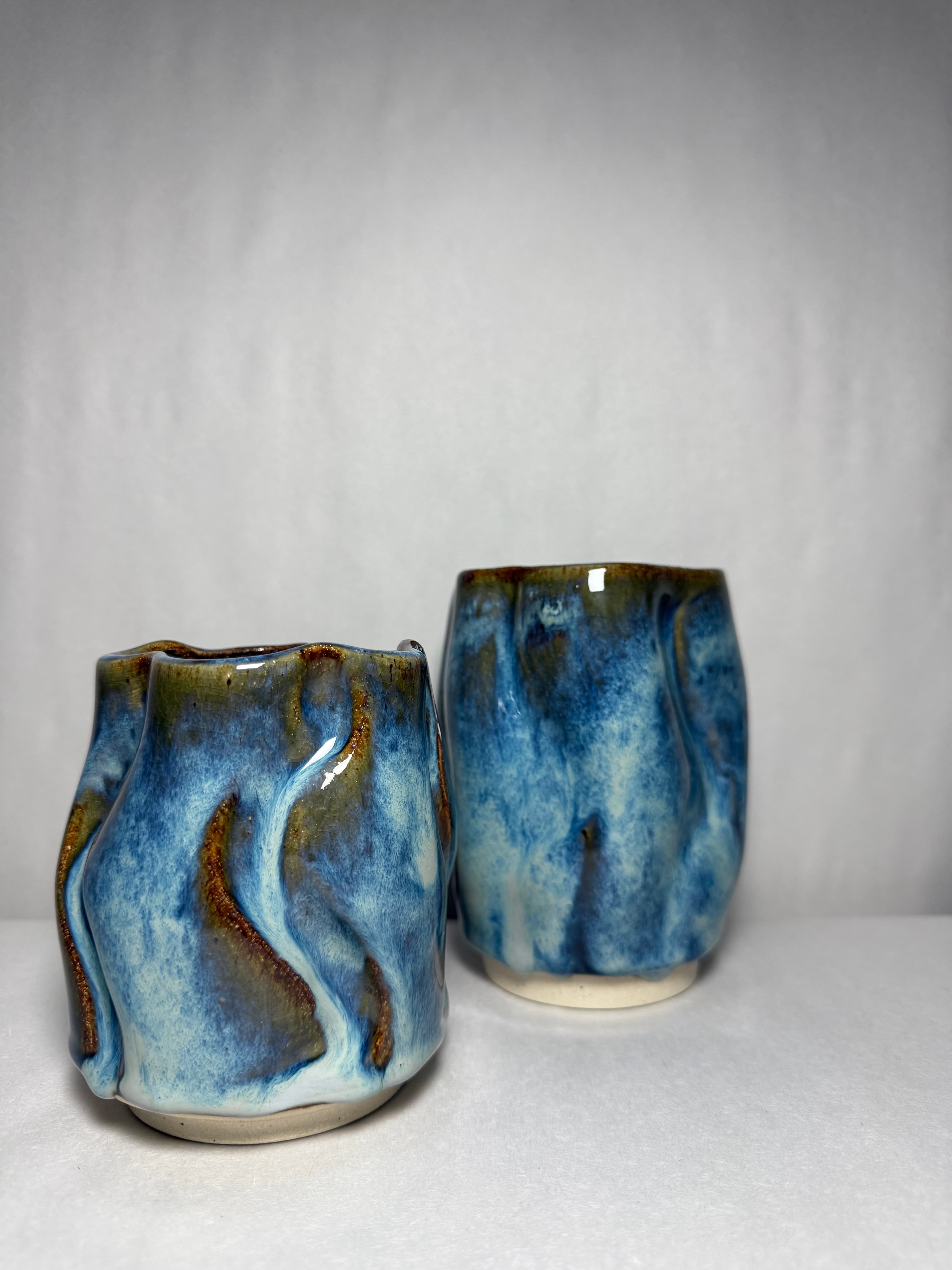 Two blue crystalline mugs photographed from the base side